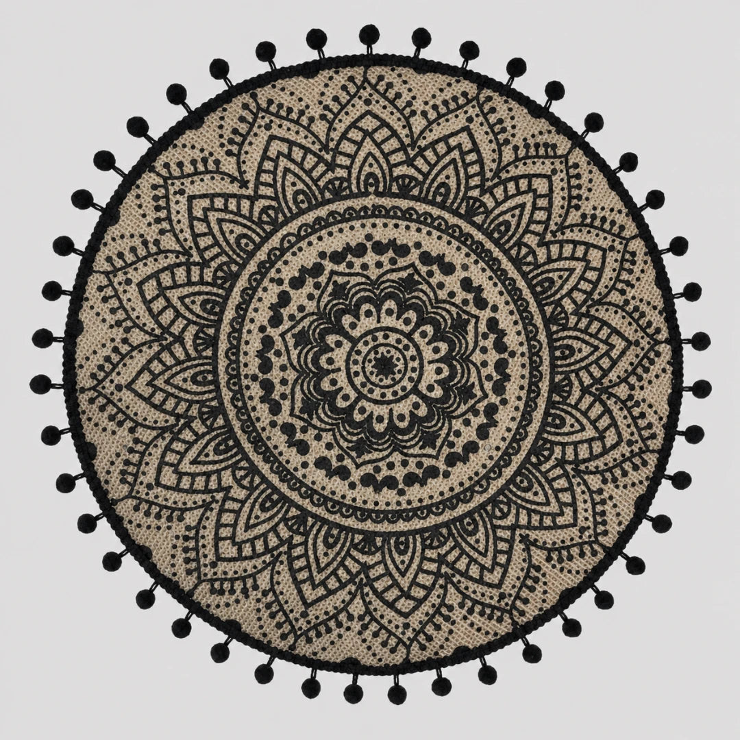 Josh & Tate - SunWeave™ Boho Mandala Placemat - A round black and beige bohemian mandala tapestry with a black pom-pom border, displayed flat against a light gray background.
