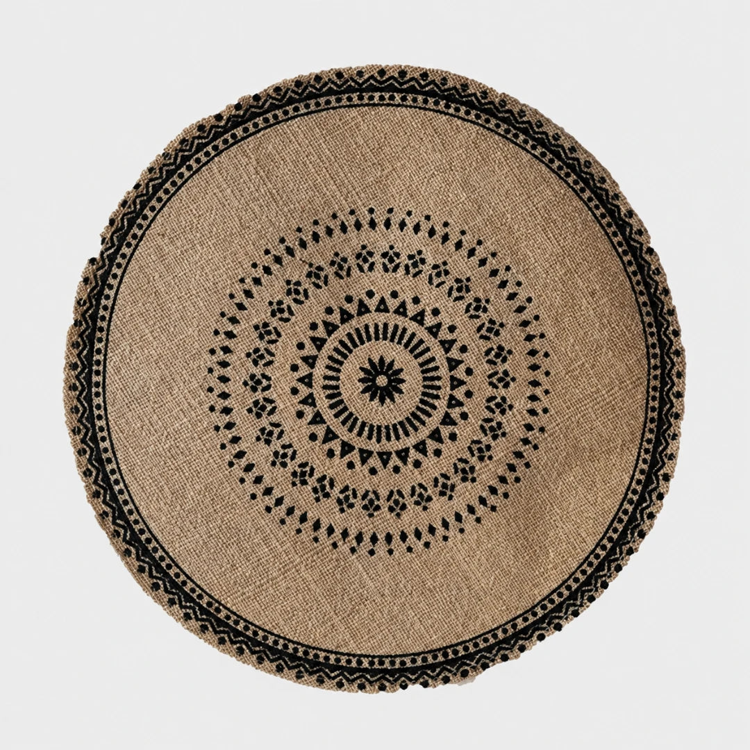 Josh & Tate - SunWeave™ Boho Mandala Placemat - A round natural jute rug with a black geometric mandala pattern and a decorative braided border, shown from a top-down view on a light gray background.