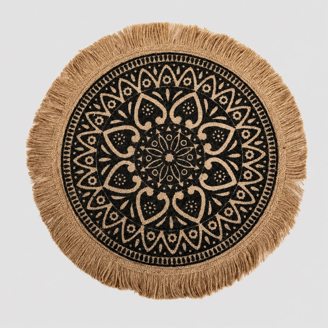 Josh & Tate - SunWeave™ Boho Mandala Placemat - Round woven throw pillow cover with a black and beige mandala pattern and fringed edges, shown on a light gray background.