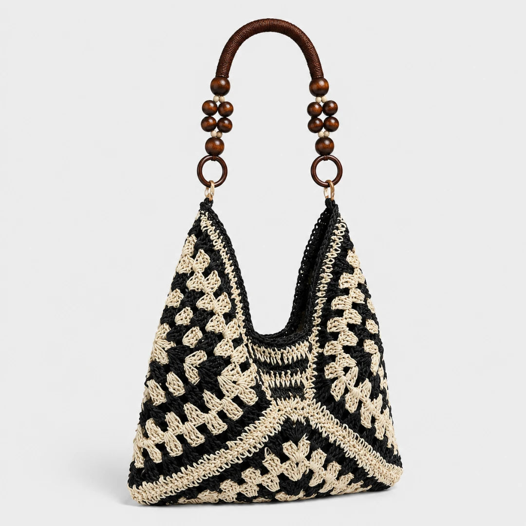Josh & Tate - SunWeave™ Crochet Hobo Bag - A black and cream crocheted shoulder bag with a curved wooden top handle decorated with dark brown beads and gold-tone rings, shown against a light gray background.