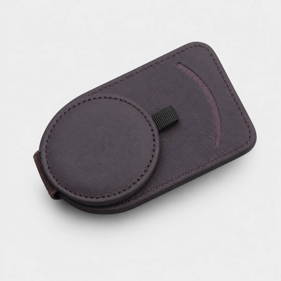 Josh & Tate - SunglassClip™ Car Visor Organizer - A dark purple magnetic phone case with a circular magnetic ring and a small black strap, shown on a light gray background.