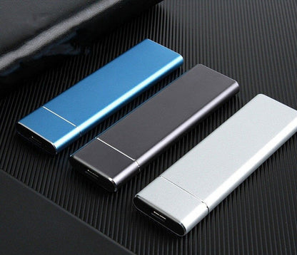 Three metallic USB drives in blue, black, and silver on a textured surface