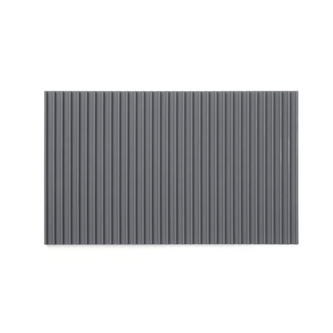 A gray non-slip mat with a ribbed texture designed to fit on a cutting board to provide stability during use.
