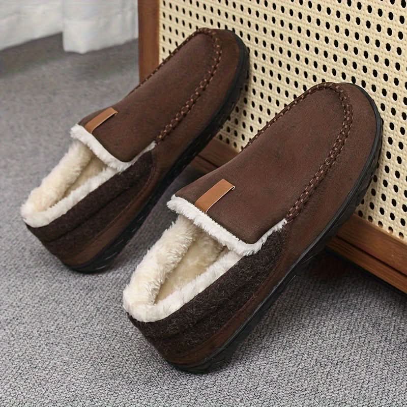 Brown slippers with white fur lining on a textured surface