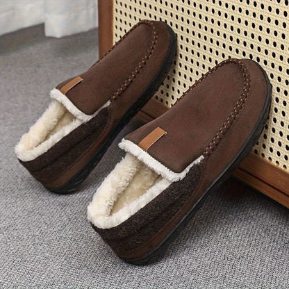 Brown slippers with white fur lining on a textured surface