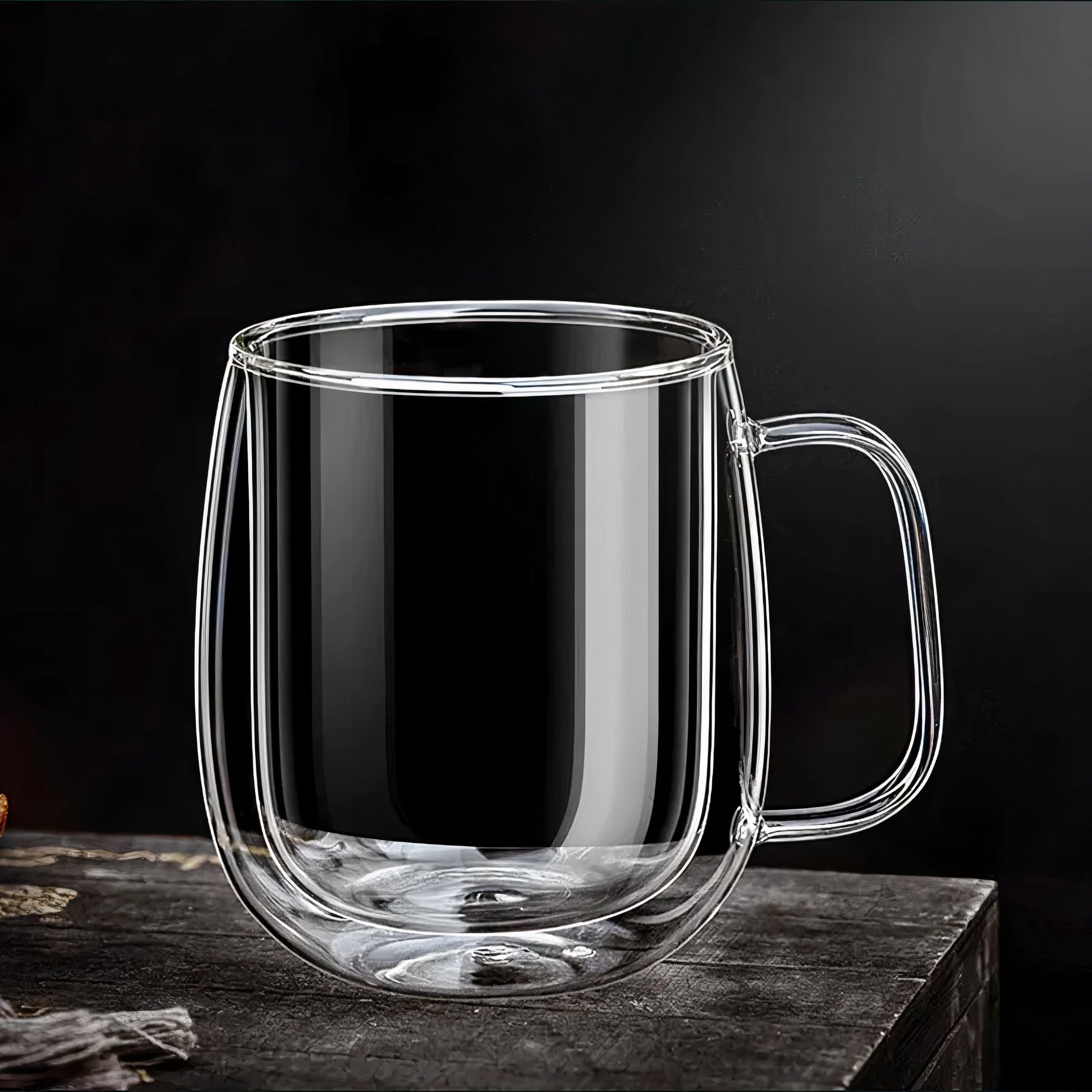 Clear glass mug with handle on a dark surface and background