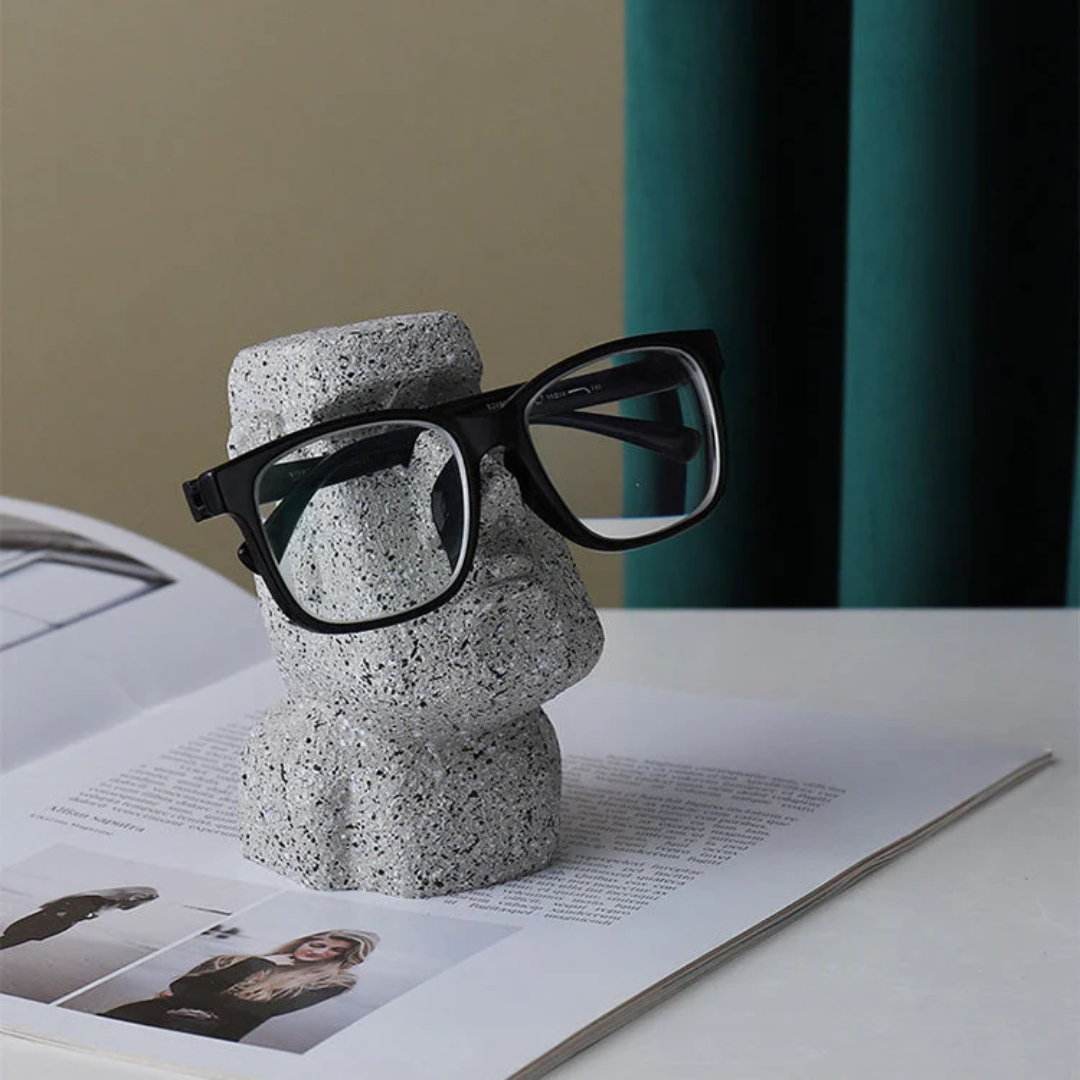 Concrete sculpture with glasses on a surface with a magazine underneath