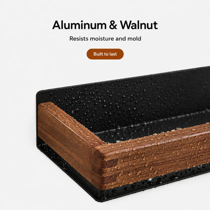 Josh & Tate - TimberLedge™ Wall Organizer - Close-up of a rectangular planter or tray corner showing a black textured exterior and a warm brown wood-grain interior, with text above reading 'Aluminum & Walnut' and 'Built to last' on a light gray background.