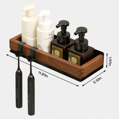 Josh & Tate - TimberLedge™ Wall Organizer - A wooden bathroom organizer tray with black clips holding two black electric toothbrushes and several toiletry bottles, shown on a light gray background with dimension arrows and labels.