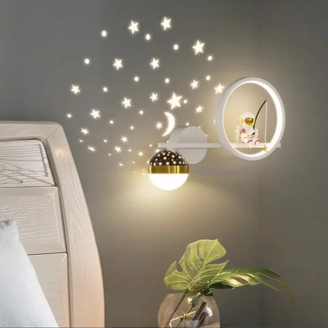 Decorative wall lights with star and moon decals on a wall.