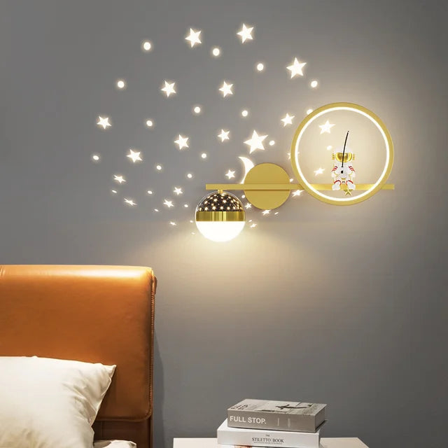 Decorative wall lights with star and moon designs on a gray wall.