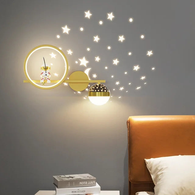 Decorative wall lights with star decals on a gray wall above a bed.