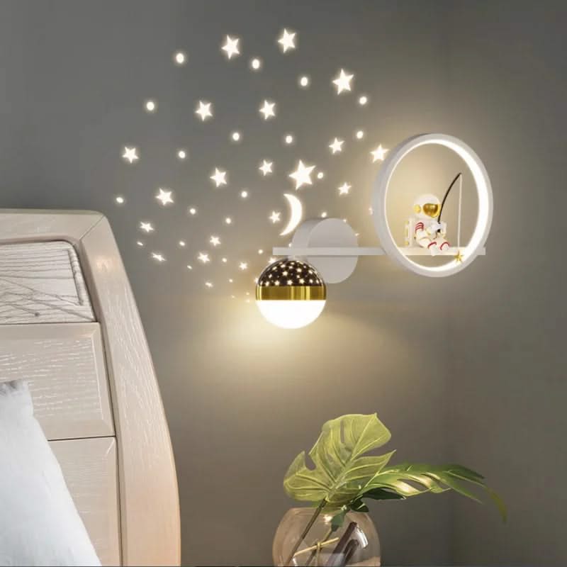 Decorative wall lights with star stickers on a wall above a bed.