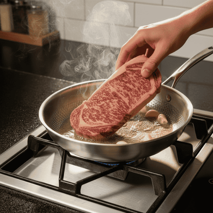 Person searing a thick cut of beef in a frying pan on a stovetop.