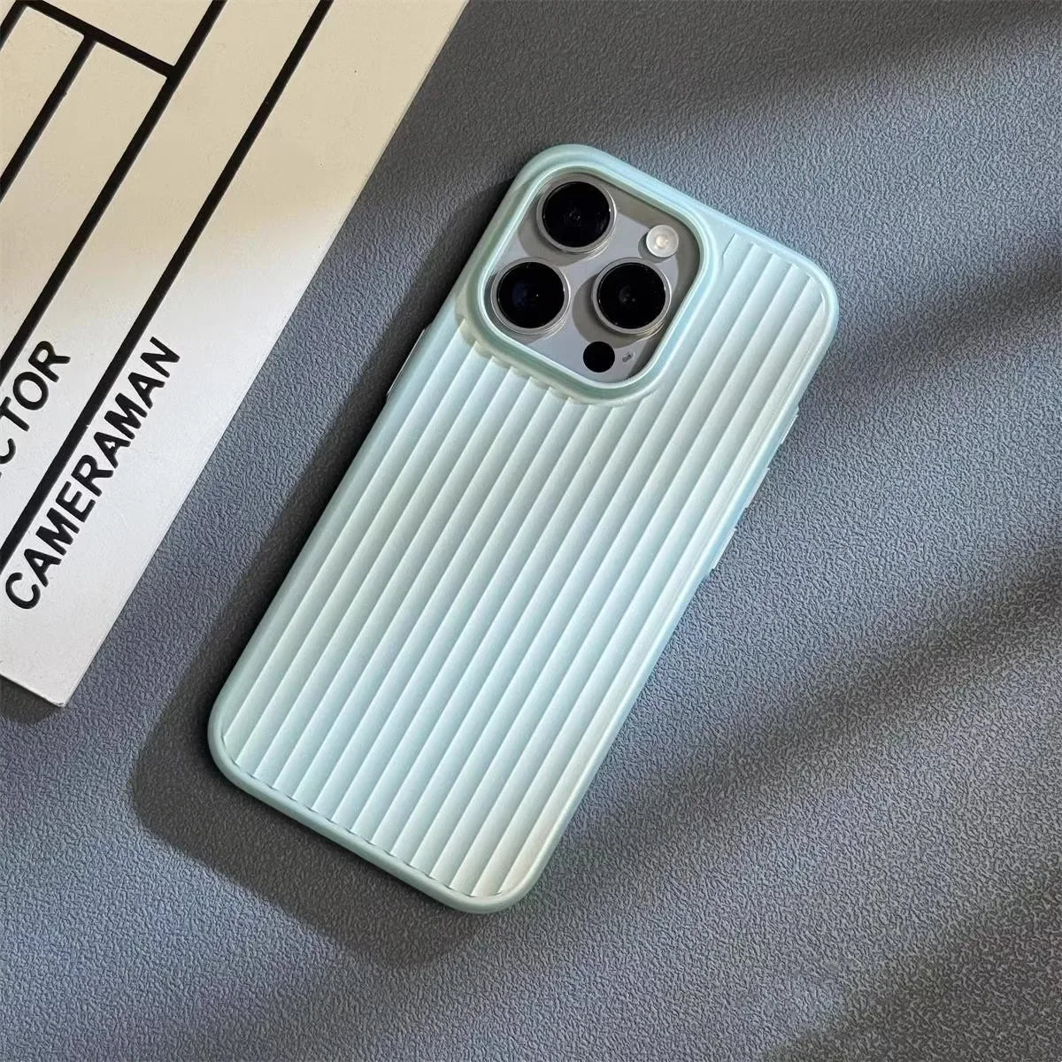 Light blue phone case on a textured surface with a camera lens visible