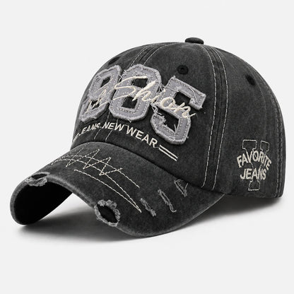 Josh & Tate - TrailFade™ '85 Cap - A distressed black washed baseball cap with embroidered details. The front features large gray and white embroidered '985' and 'Fashion' text, with 'FASHIONS NEW WEAR' underneath.