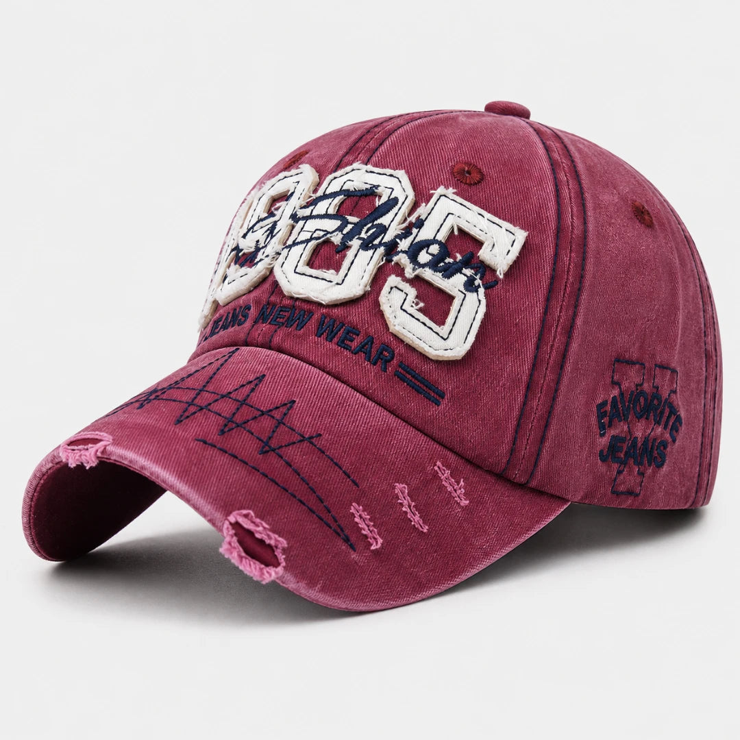 Josh & Tate - TrailFade™ '85 Cap - A washed burgundy baseball cap with distressed details, featuring 'Favoritos' embroidered in white and navy on the front, and 'Favorito Jeans' on the side.