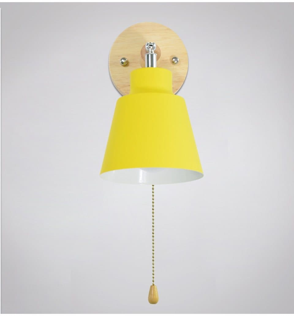 Wall lamp with yellow shade and wooden base on a light gray background