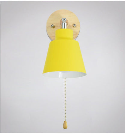 Wall lamp with yellow shade and wooden base on a light gray background