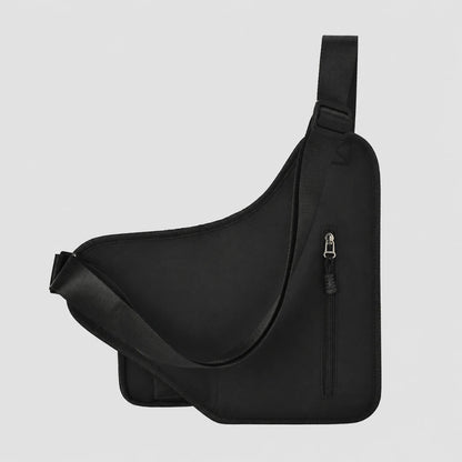 Josh & Tate - UrbanCore™ Crossbody Bag - A black asymmetrical sling bag with an adjustable shoulder strap and a vertical zippered pocket, shown against a light gray background.