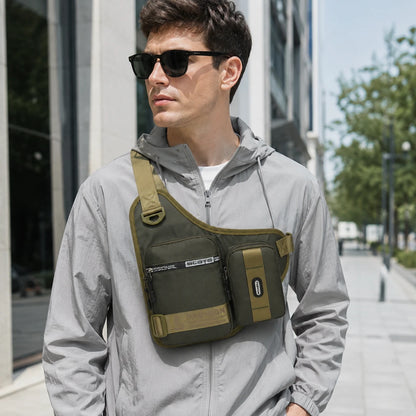 Josh & Tate - UrbanCore™ Crossbody Bag - A man wearing a gray hooded jacket and black sunglasses models an olive green and khaki sling bag across his chest in an outdoor urban setting.