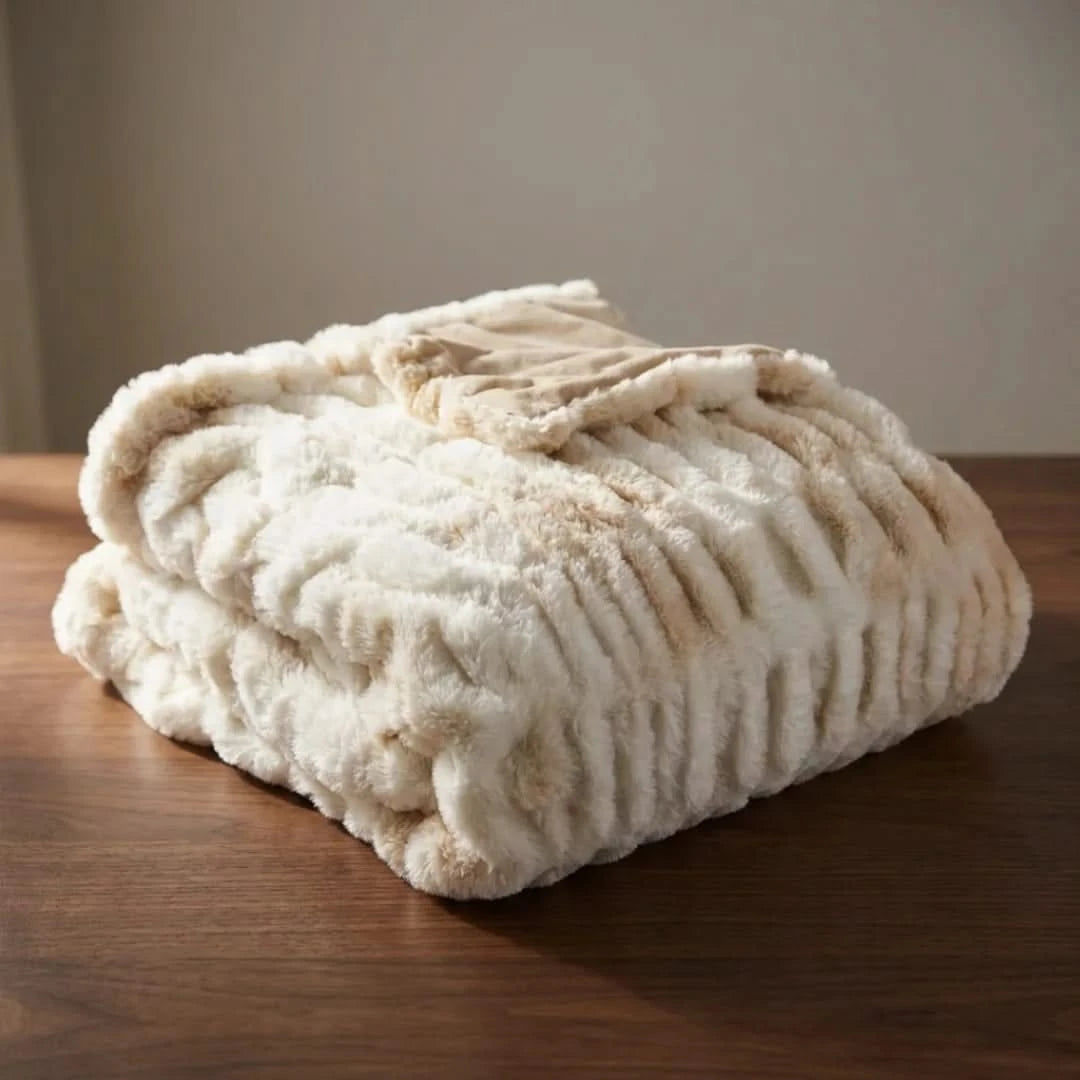 Josh & Tate - VelvetRib™ Faux Fur Throw Blanket - Folded beige blanket on a wooden surface with a neutral background