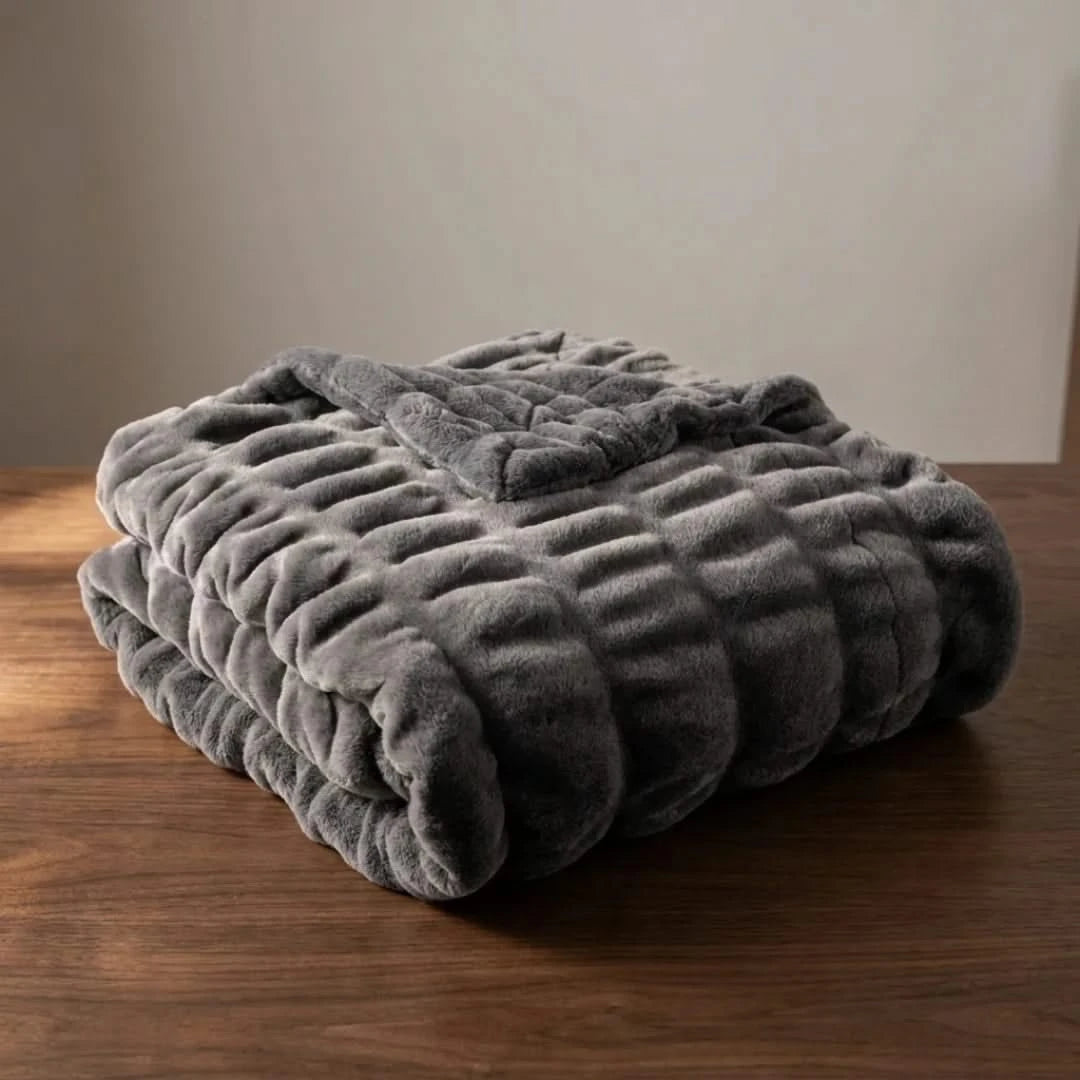 Josh & Tate - VelvetRib™ Faux Fur Throw Blanket - Folded gray blanket on a wooden surface with a neutral background