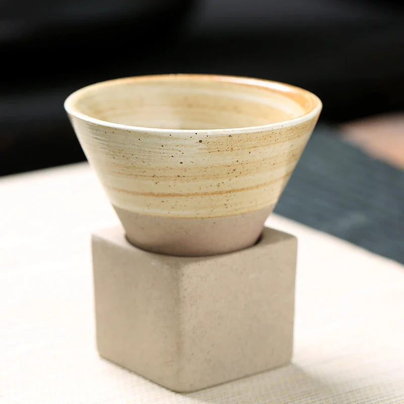 Ceramic cup on a textured block with a blurred background