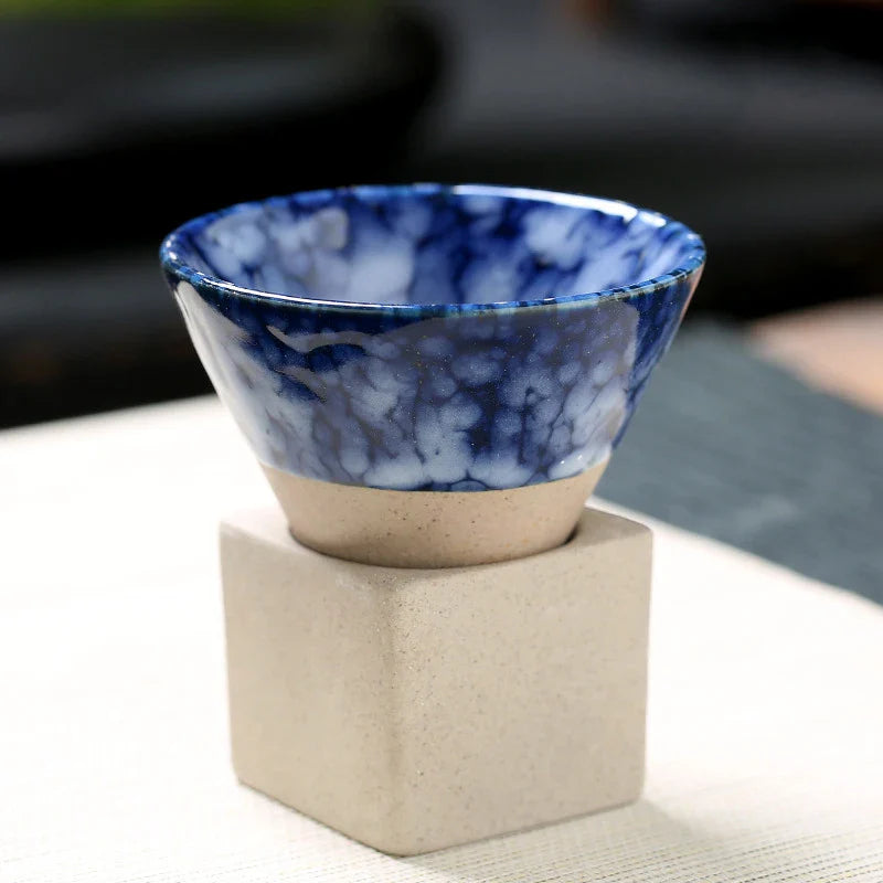 Ceramic bowl with blue marbled design on a beige stand