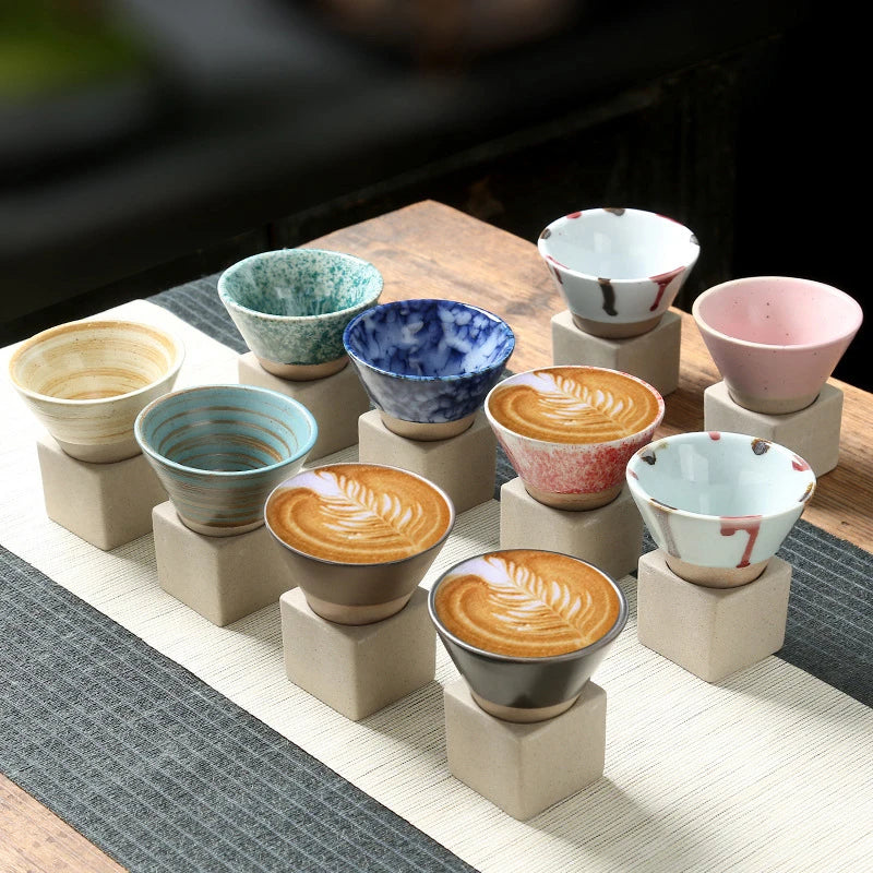 Set of colorful ceramic cups on wooden blocks with a blurred background