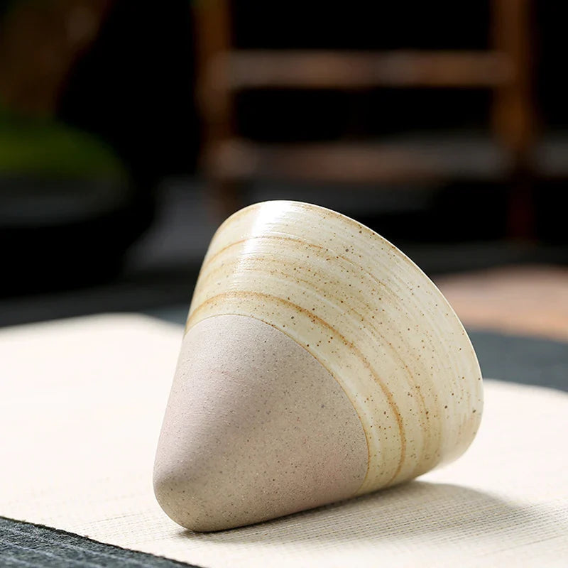 Triangular ceramic object on a textured surface with a blurred background