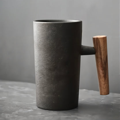 Dark gray mug with a wooden handle on a gray surface