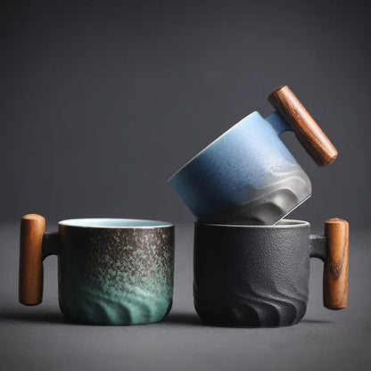 Three ceramic mugs with wooden handles on a dark background