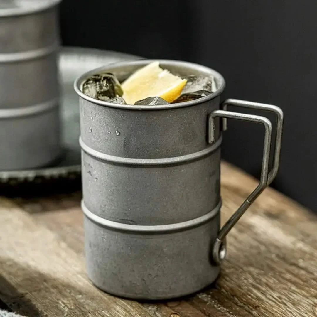 Josh & Tate - Vintage Steel Mug (13oz / 380mL) - Metallic mug with a drink and lemon wedge on a wooden surface