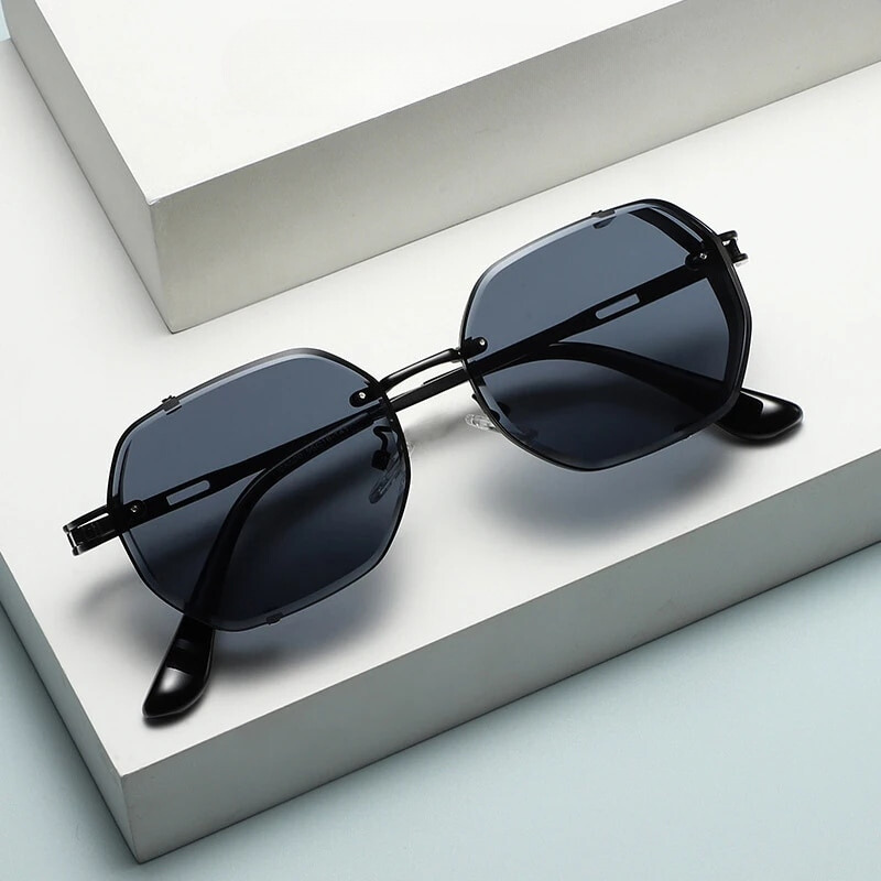 Black sunglasses with dark lenses on a white surface