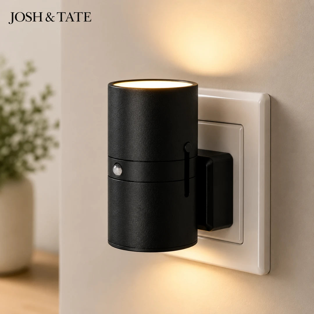 Josh & Tate - WallBeam™ Plug-In Directional Sconce - Black wall-mounted light fixture on a beige wall with 'JOSH & TATE' branding.