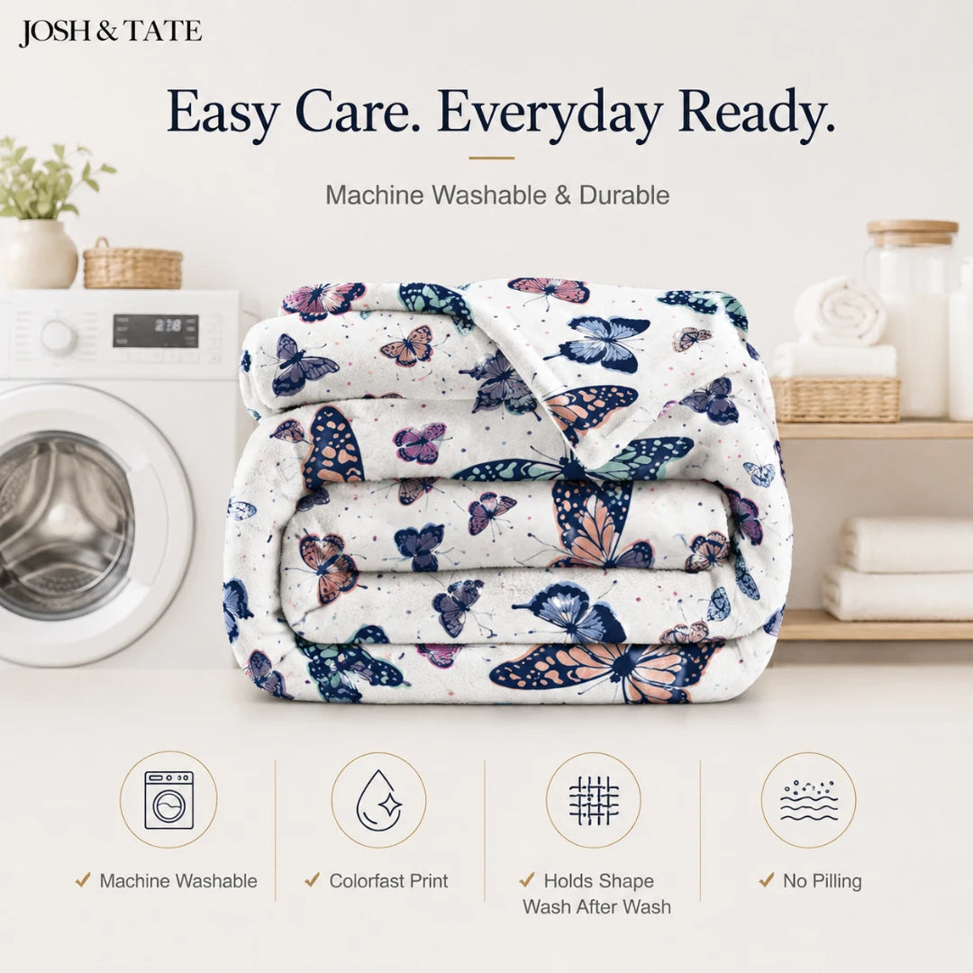 Josh & Tate - WingWrap™ Butterfly Throw Blanket - Folded blanket with butterfly pattern on a washing machine, featuring Josh & Tate branding.