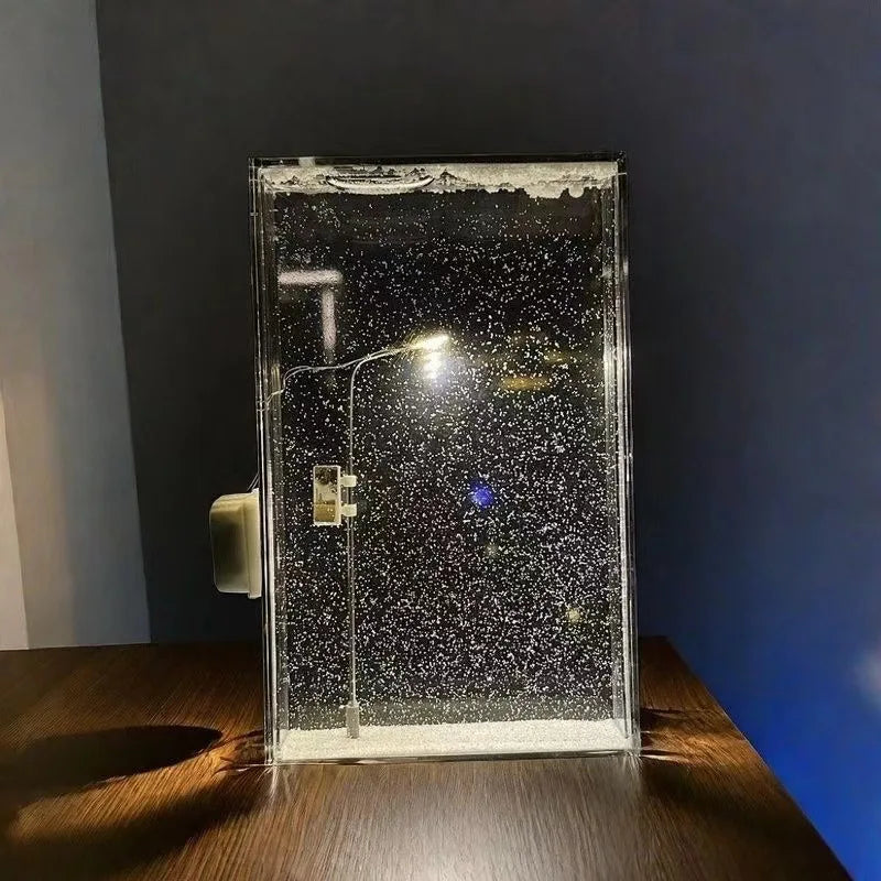 Glass display case with water droplets on a wooden surface against a dark wall.