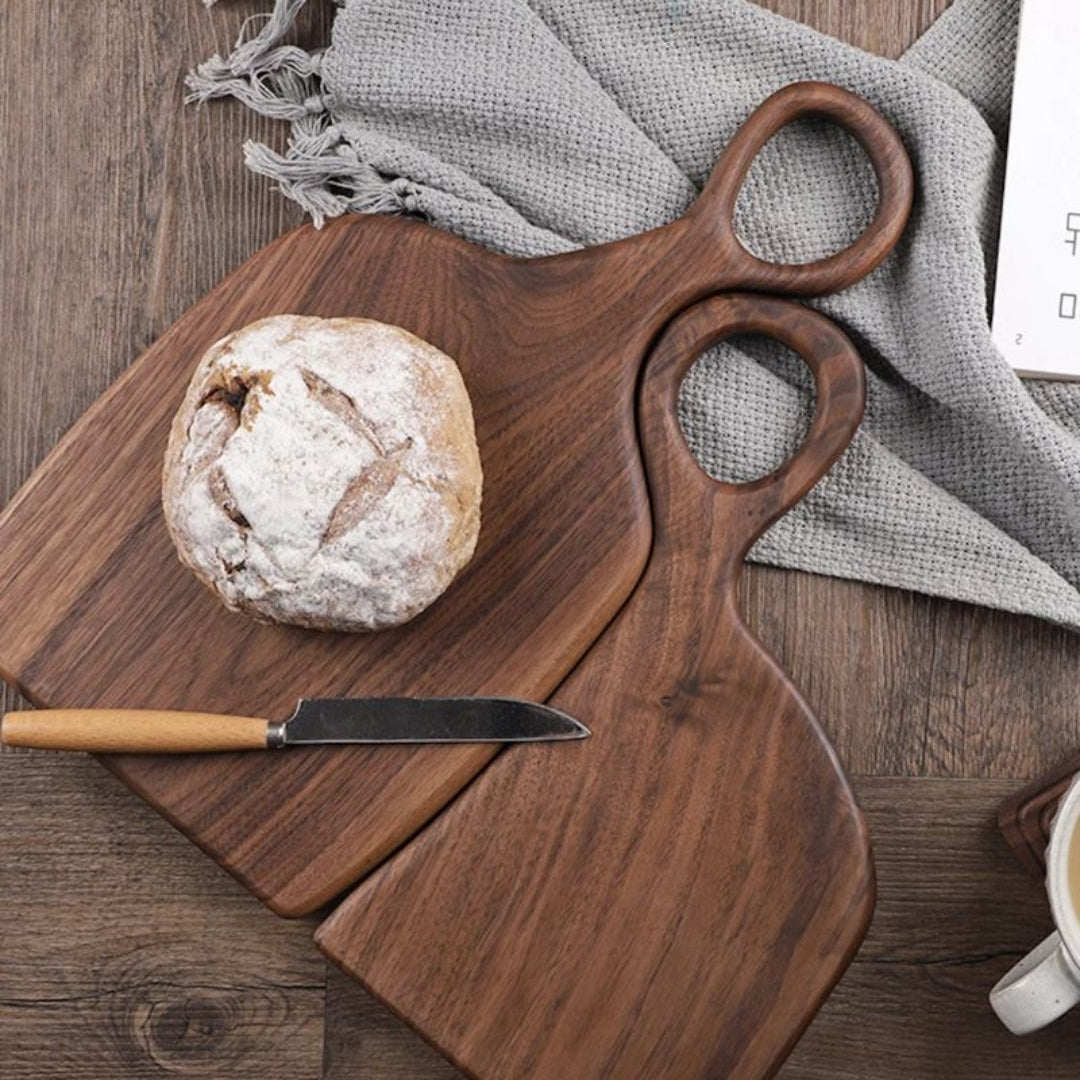 Wooden cutting board with bread and knife on a wooden surface