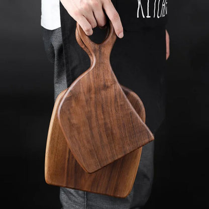 Person holding two wooden cutting boards with a dark background