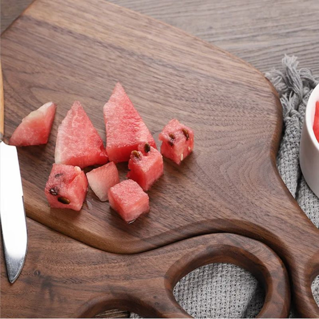 Sliced watermelon on a wooden cutting board with a knife