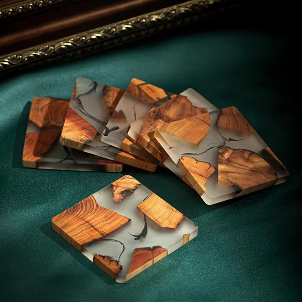 Set of wooden coasters on a green surface with a decorative frame in the background.