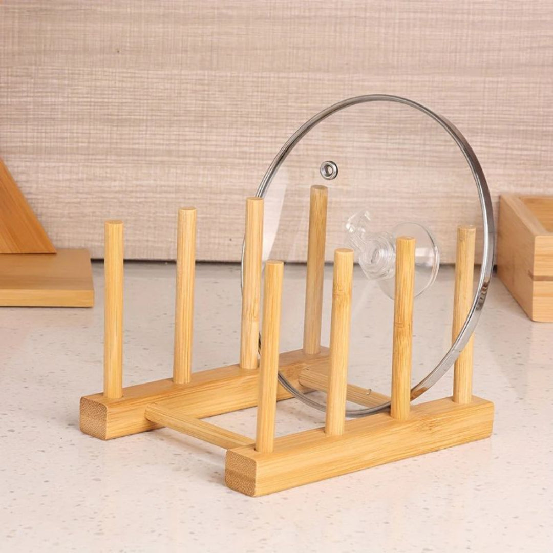 Wooden dish rack holding a glass lid on a neutral background