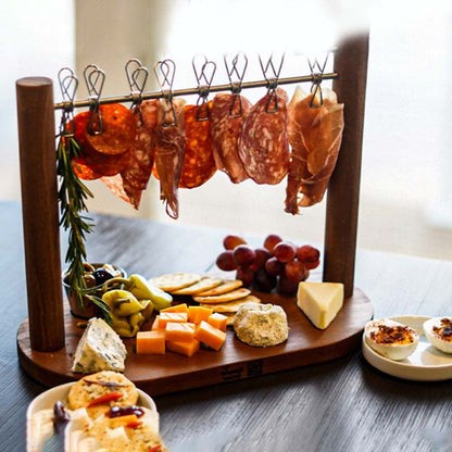 Wooden charcuterie board with cured meats, cheeses, and fruits on a table.