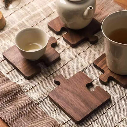 Wooden coasters on a textured surface with tea cups and a teapot.