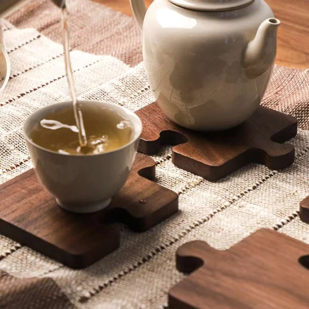 Tea being poured into a cup with a teapot on a checkered tablecloth