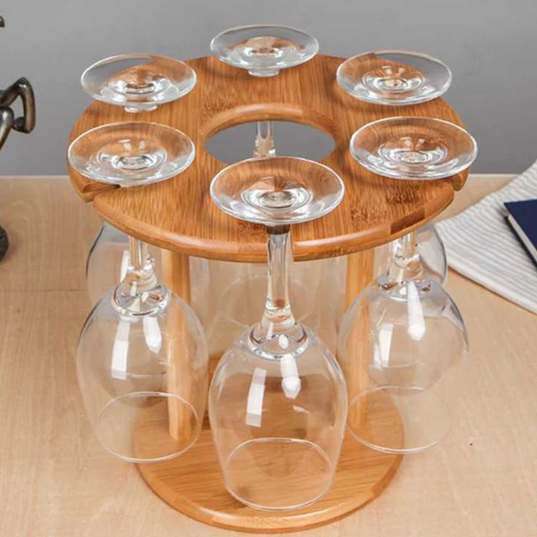 Wooden wine glass holder with six clear wine glasses on a wooden surface.