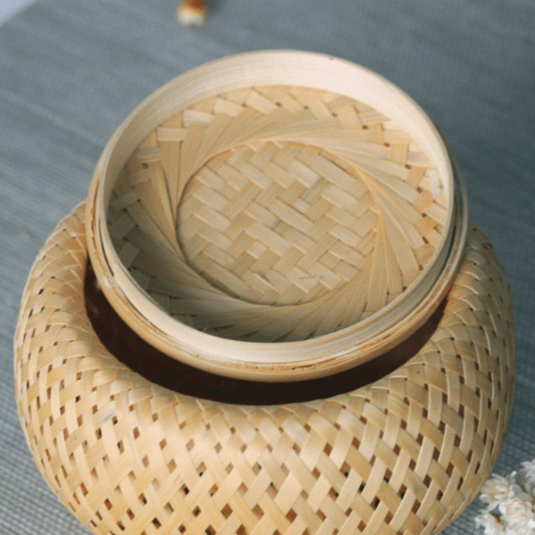 Woven bamboo container with lid on a textured surface
