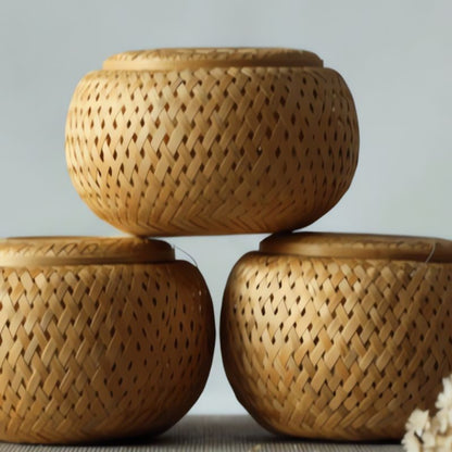 Three woven bamboo containers stacked on a light gray background